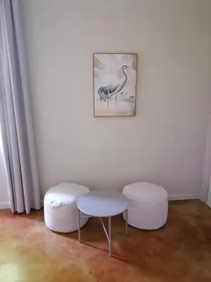 a room with two stools and a table and a picture at Shingalana Cottages in White River