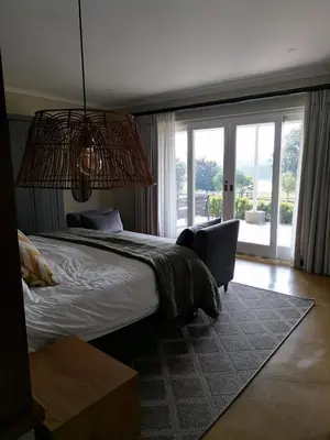 a bedroom with a large bed and a large window at Shingalana Cottages in White River