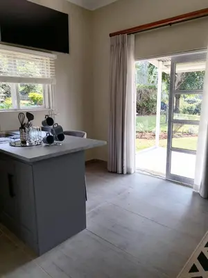 a kitchen with a counter and a large sliding glass door at Shingalana Cottages in White River