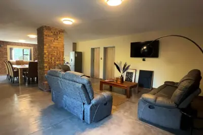 a living room with two blue couches and a table at Melamar Estate in Marloth Park