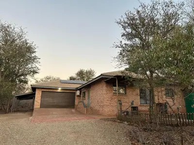 a brick house with a garage and a fence at Melamar Estate in Marloth Park