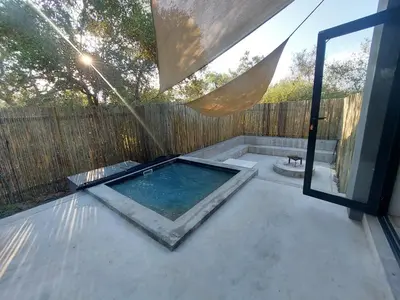 a swimming pool on a patio with a fence at House UmGanu in Marloth Park