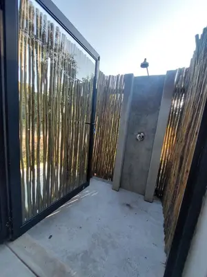 a gate with a fence with a view of trees at House UmGanu in Marloth Park