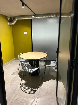 a table and chairs in a room with yellow walls at Circa Lynnwood Studio in Pretoria