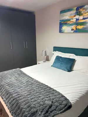 a bedroom with a large bed with a blue pillow at Circa Lynnwood Studio in Pretoria