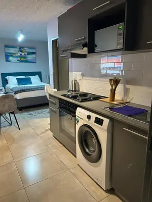 a kitchen with a stove and a washing machine at Circa Lynnwood Studio in Pretoria