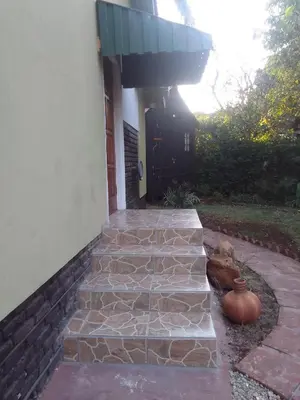 a stone walkway in front of a house with a vase at Buffalo Street Cottages in Malelane