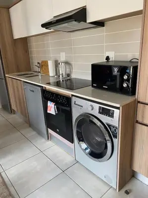 a kitchen with a washing machine and a microwave at The Blydes Pretoria in Pretoria