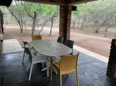 a table and chairs on a patio with a view at African Vibes in Marloth Park