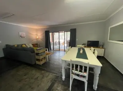a living room with a white table and a couch at African Vibes in Marloth Park