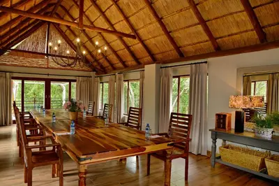 a dining room with a large wooden table and chairs at Thanda Manzi Country Hotel in Centurion