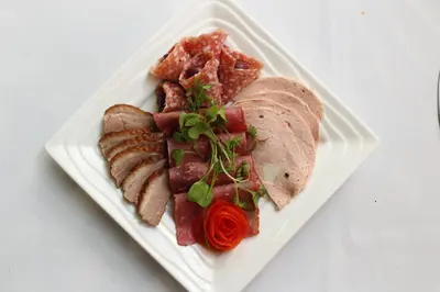 a white plate of food with meat and meats at Thanda Manzi Country Hotel in Centurion