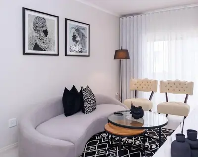 a living room with a white couch and a table at Luminant Escapes - with power backup in Midrand