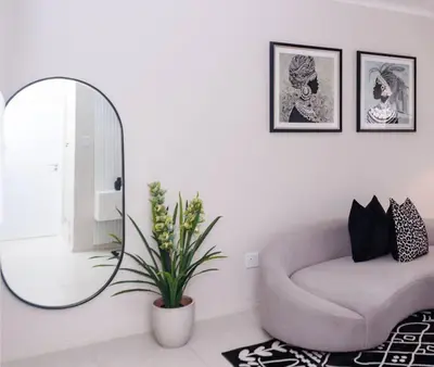 a living room with a chair and a mirror at Luminant Escapes - with power backup in Midrand