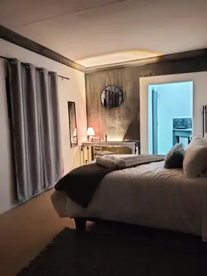 a bedroom with a large bed and a dining room at 20 on Middle in Polokwane