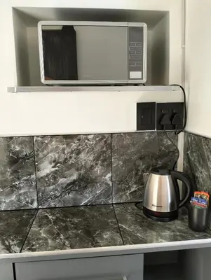 a microwave above a stove with a tea kettle at 20 on Middle in Polokwane