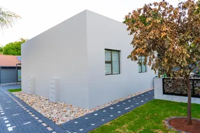 a white house with a tree in front of it at Homes of Ace Studio 1 in Pretoria