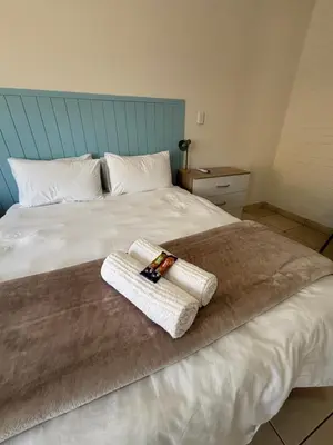 a bedroom with a bed with two towels on it at 59 van Heerden in Mokopane