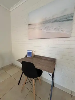 a desk with a chair and a laptop on it at 59 van Heerden in Mokopane