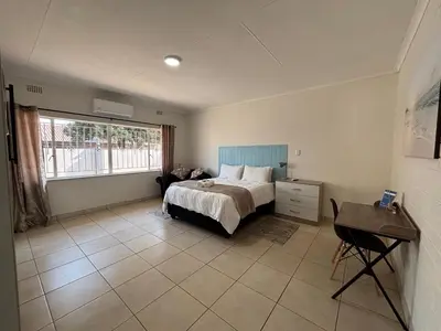 a bedroom with a bed and a window and a desk at 59 van Heerden in Mokopane