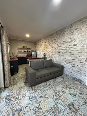 a living room with a couch and a brick wall at 59 van Heerden in Mokopane