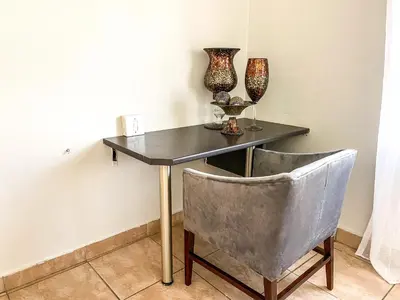 a table and a chair with vases and glasses on it at Bobisemo Lux Guesthouse in Tierpoort