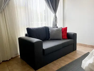 a couch with two pillows sitting in front of a window at Bobisemo Lux Guesthouse in Tierpoort