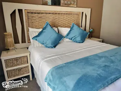 a large bed with blue pillows in a bedroom at Misty View House in Dullstroom