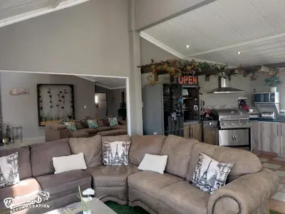 a living room with a couch and a kitchen at Misty View House in Dullstroom
