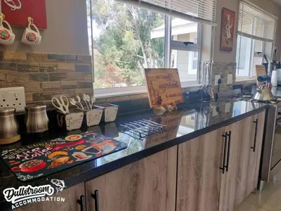 a kitchen with a counter top and a window at Misty View House in Dullstroom