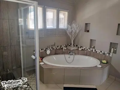 a large bathroom with a tub and a shower at Misty View House in Dullstroom