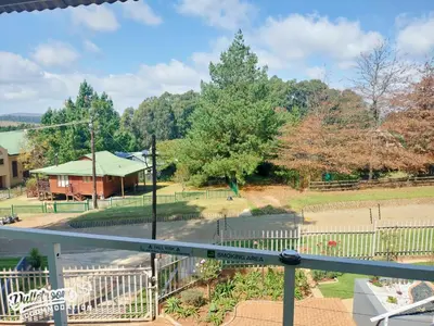 a view of a park from the balcony of a house at Misty View House in Dullstroom