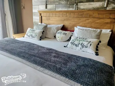 a bed with pillows on top of it at Misty View House in Dullstroom