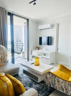 a living room with a couch and a table at Waterfall Peaceful Oyster in Midrand