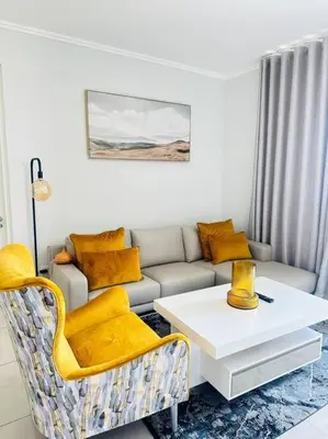 a living room with a couch and a table at Waterfall Peaceful Oyster in Midrand