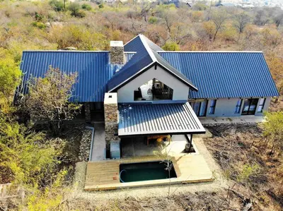 an aerial view of a house with a blue roof at Ebony House - Kruger National Park in Hectorspruit