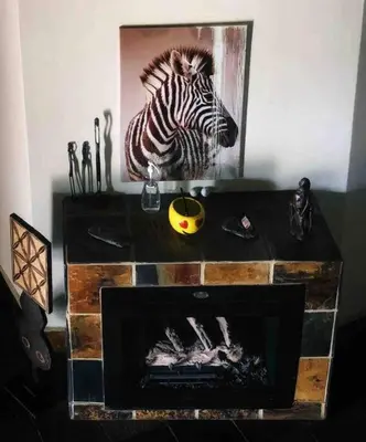 a fireplace in a room with a picture of a zebra at The Yellow House in Brits