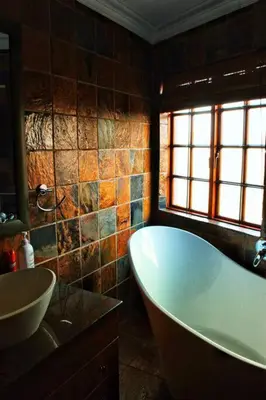 a bathroom with a bath tub and a sink at The Yellow House in Brits