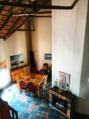 a dining room with a table and a fireplace at The Yellow House in Brits