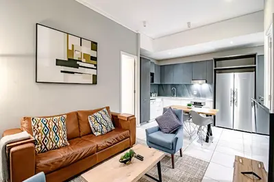 a living room with a couch and a table at Penthouse and Apartment at The Capital Triology Menlyn Maine in Pretoria