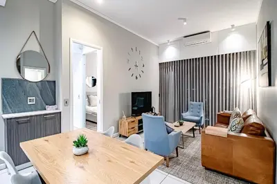 a living room with a table and a dining room at Penthouse and Apartment at The Capital Triology Menlyn Maine in Pretoria