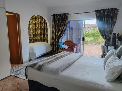 a bedroom with a bed and a window with a chair at Sun and Stars in Benoni