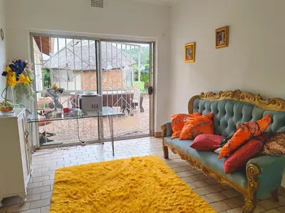 a living room with a couch and a large window at Sun and Stars in Benoni