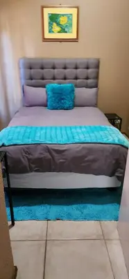 a bed with a blue pillow on top of it at 20 Pendleberry Holiday Resort in Bela-Bela