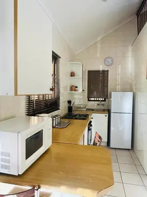 a kitchen with a white microwave and a refrigerator at 20 Pendleberry Holiday Resort in Bela-Bela