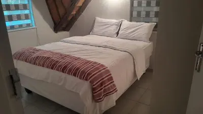 a bed with white sheets and pillows in a room at Mandy place in Sandown