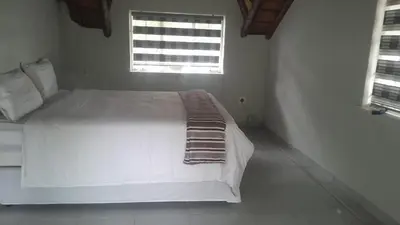 a white bed in a room with a window at Mandy place in Sandown
