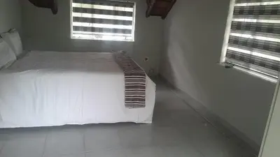 a bedroom with a white bed and two windows at Mandy place in Sandown