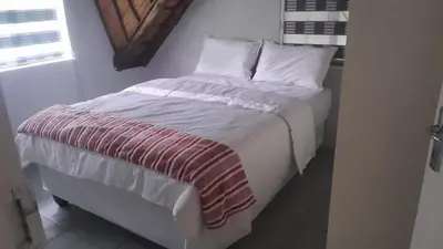 a bed with white sheets and pillows in a room at Mandy place in Sandown