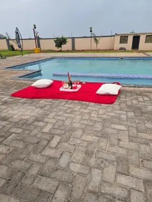 a pool with a red rug with two pillows on it at KGADITSE ROAD LODGE in Moletlane